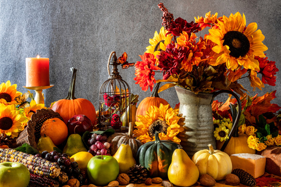 a whole spread of fall foods and foliage with butterflies flying around
