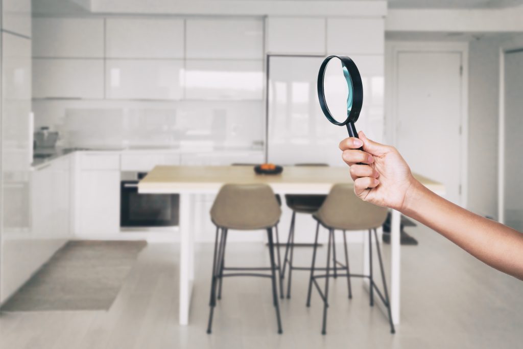 magnifying glass inspector looking at kitchen house background.